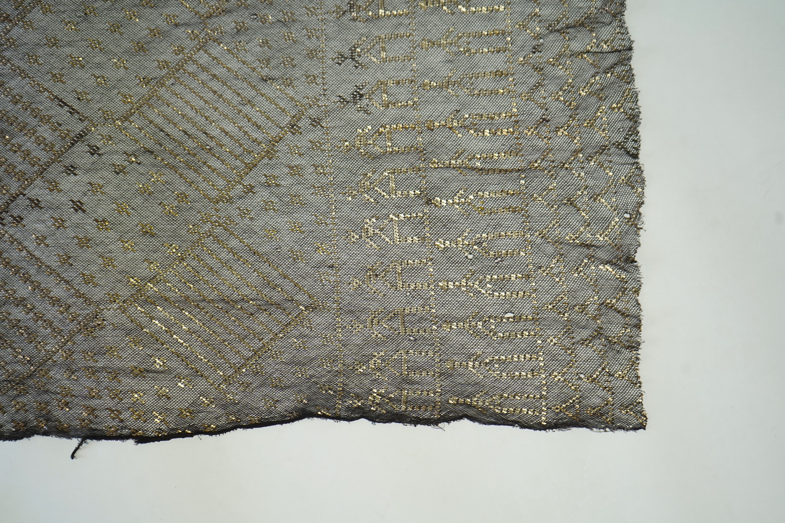A 1930’s Egyptian decorative metal on black net evening stole. Approximately 218cm long. Condition - the rolled edges are frayed but the colour and design are intact.